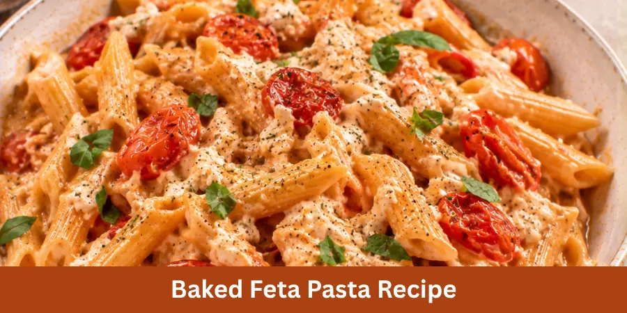 A creamy Baked Feta Pasta served in a neutral ceramic bowl with baked feta, roasted tomatoes and pasta on a warm kitchen table, presented as a finished pasta recipe.