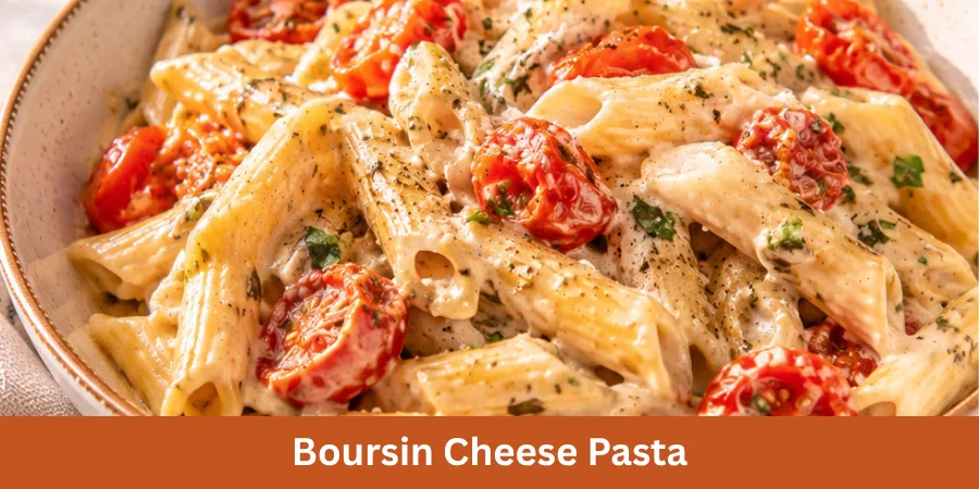 A bowl of creamy Boursin Cheese Pasta with roasted tomatoes on a neutral kitchen or dining surface, photographed from a three-quarter angle.