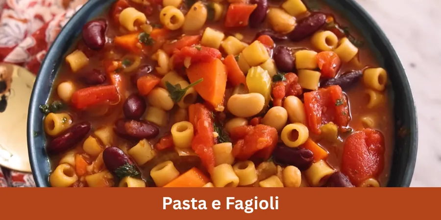A bowl of homemade Pasta e Fagioli served on a dining surface in a simple home kitchen, photographed from a three-quarter angle with soft natural daylight.