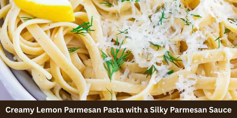 A close view of creamy lemon Parmesan pasta with silky Parmesan sauce coating the pasta, with the front portion sharply focused and a subtle lemon garnish nearby.